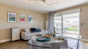 Un comedor moderno con una mesa redonda, sillas transparentes y vistas al exterior.