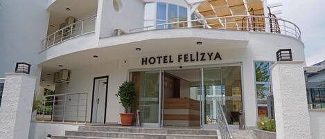 Un hotel moderno con fachada curva, una entrada destacada y una escalera que conduce a la entrada.