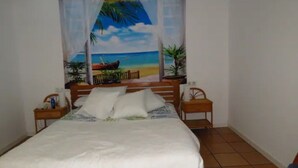 A bedroom with a bed, two nightstands, a window with a beach scene curtain, and a tiled floor. - Casa de invitados adaptada. (Santa cristina d'Aro)