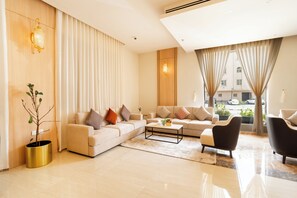 A modern living room with a sofa set, a coffee table, and a potted plant. - Innyar Hotel (Riyadh)