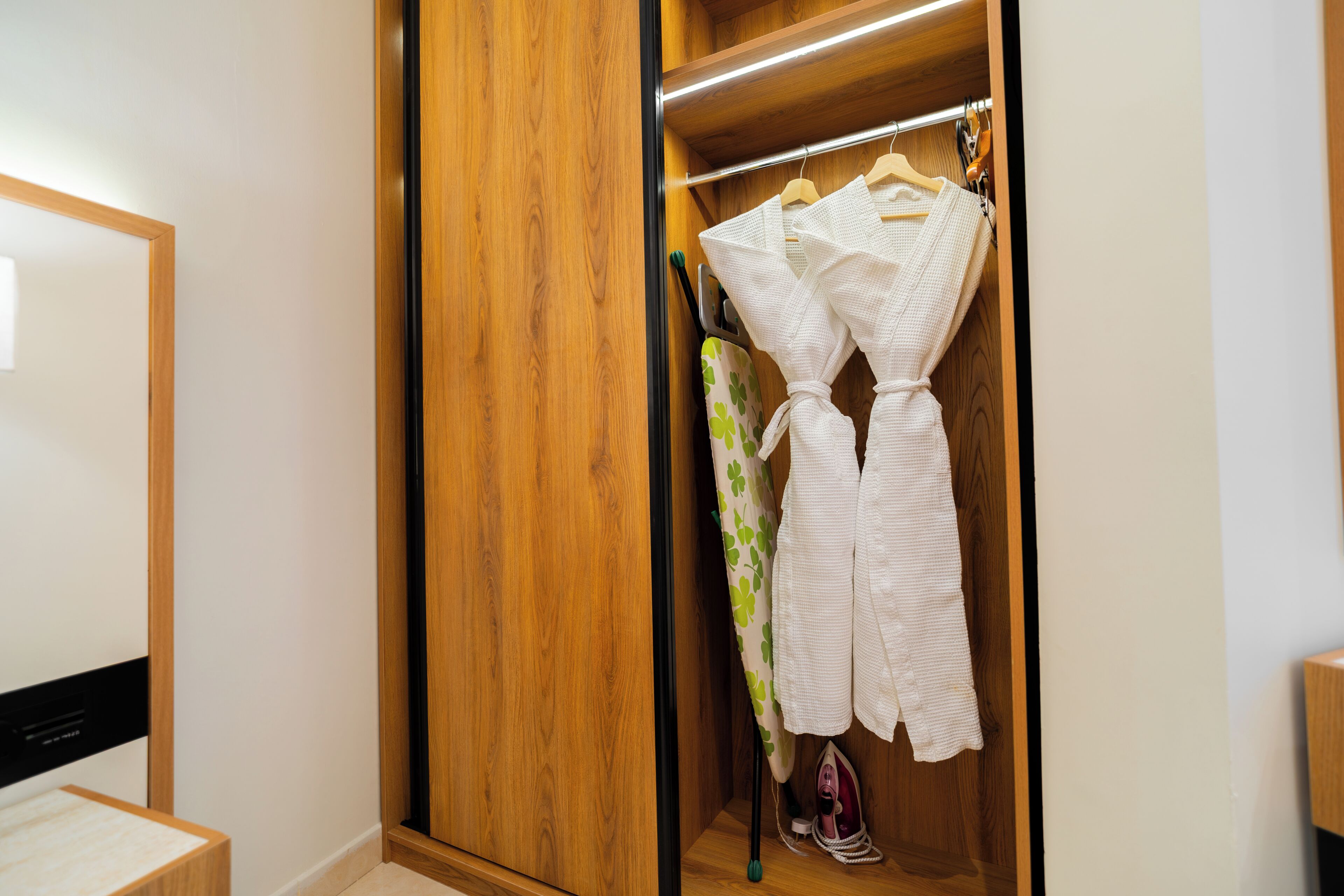 Une armoire en bois avec une tringle à vêtements à l’intérieur.