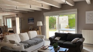 A spacious living room with two sofas, a coffee table, and a lamp. - Charming renovated country house Chéray Oléron ( 3 stars) (saint georges d'oléron)