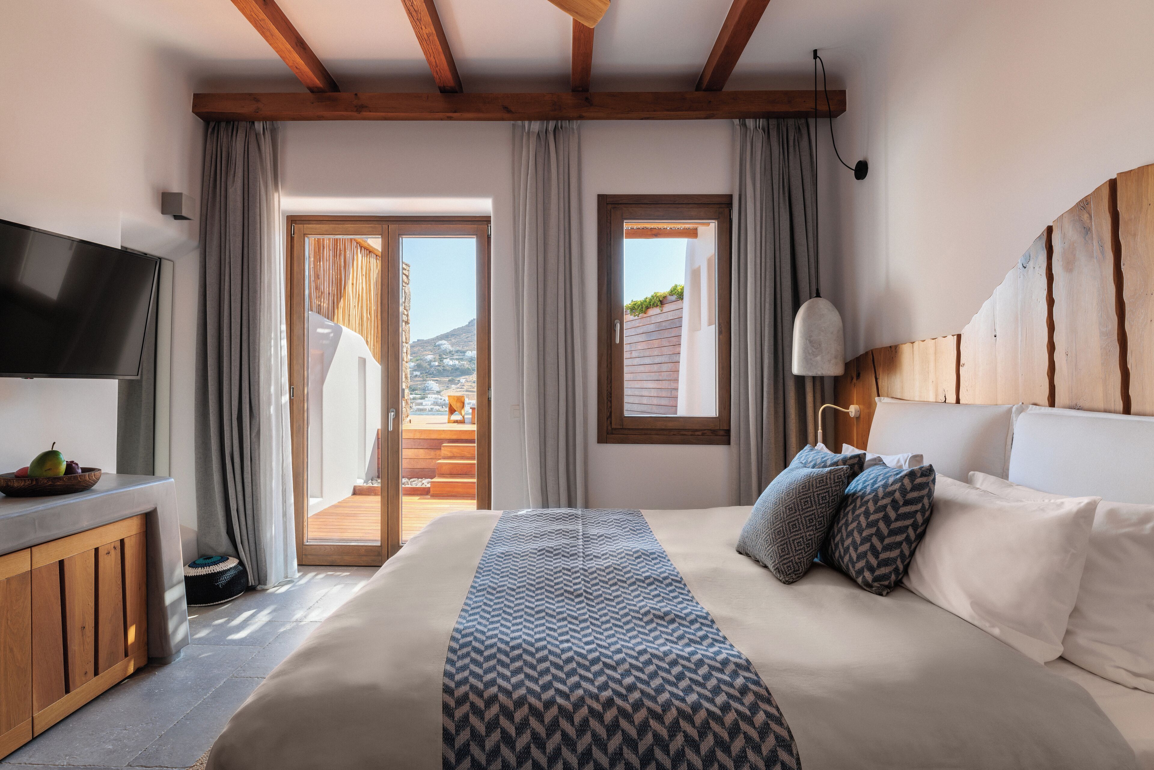 Een slaapkamer met een groot bed, een televisie en uitzicht op de omgeving.
