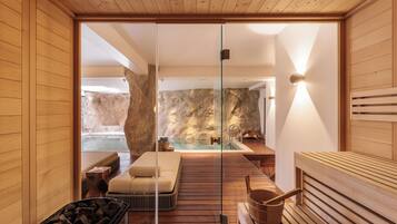 Relax in a serene spa room with a wooden floor, glass partition, and a massage table.