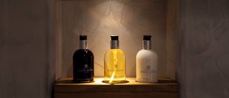 Una estantería con tres botellas de productos Molton Brown.