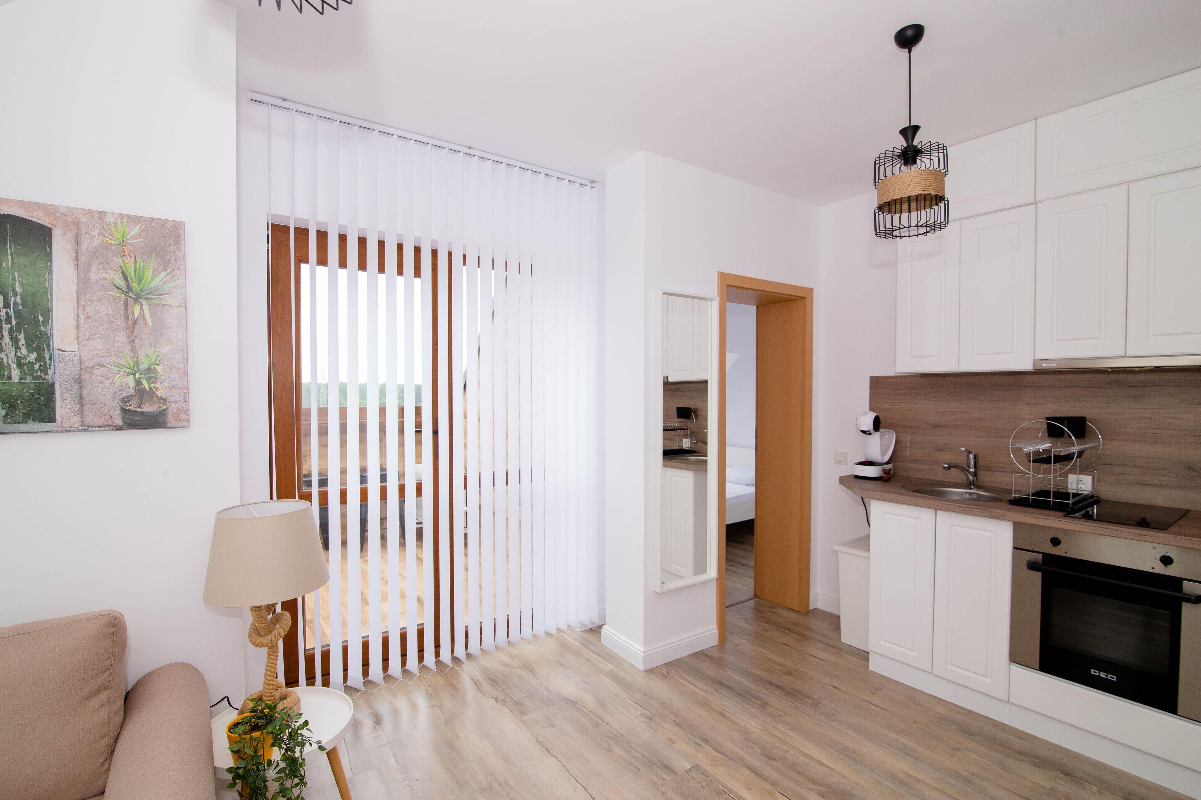 Una cocina moderna con armarios blancos, encimera de madera y horno empotrado.
