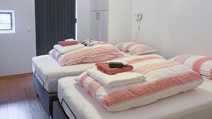 Une chambre d'hôtel avec deux lits, chacun étant équipé de draps à rayures et d'une serviette pliée.