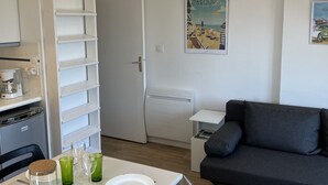 Eine moderne Küche mit weißen Schränken, einer Kaffeemaschine und einem Esstisch, gedeckt mit Tellern und Gläsern.