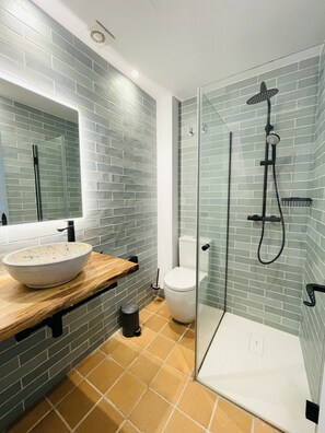 Een douche, een haardroger, handdoeken, toiletpapier