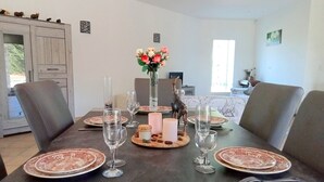 Een eettafel gedekt met borden, glazen en een middelpunt.
