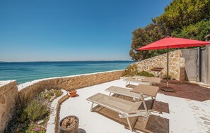 A patio with sun loungers and a red umbrella overlooking a coastal view. - Beautiful apartment in Petrcane with WiFi (Petrcane)