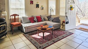 A cozy living room with a sectional sofa, a wooden chair, a coffee table, and a red and black patterned rug. - Fish, Hike & Explore! Family Tamassee Getaway (Tamassee)