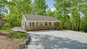 A cabin with a wooden deck, a gravel driveway, and a forested backdrop. - Fish, Hike & Explore! Family Tamassee Getaway (Tamassee)
