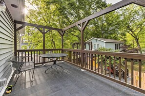 Relax in a serene outdoor space with a table and chairs, surrounded by a traditional wooden railing.
