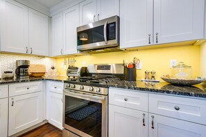 Enjoy cooking and food preparation in this well-equipped kitchen with stainless steel appliances, microwave, and oven.