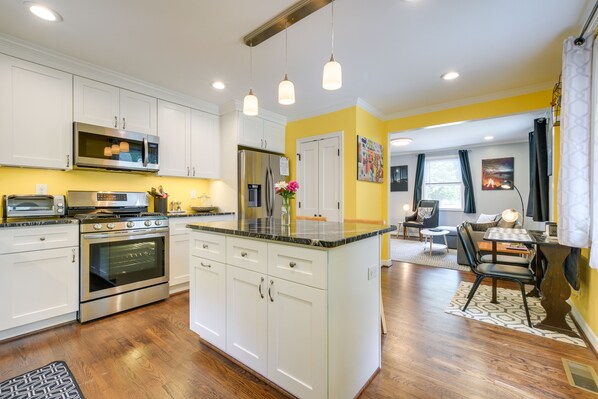Enjoy cooking in this well-equipped kitchen with a central island, stainless steel appliances, and ample cabinetry.