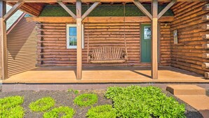 A log cabin with a porch, a green door, and a bench. - Rustic Zanesville Getaway w/ Expansive Yard! (Zanesville)