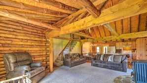 A log cabin interior with a stone fireplace, leather sofas, and a dining area. - Rustic Zanesville Getaway w/ Expansive Yard! (Zanesville)