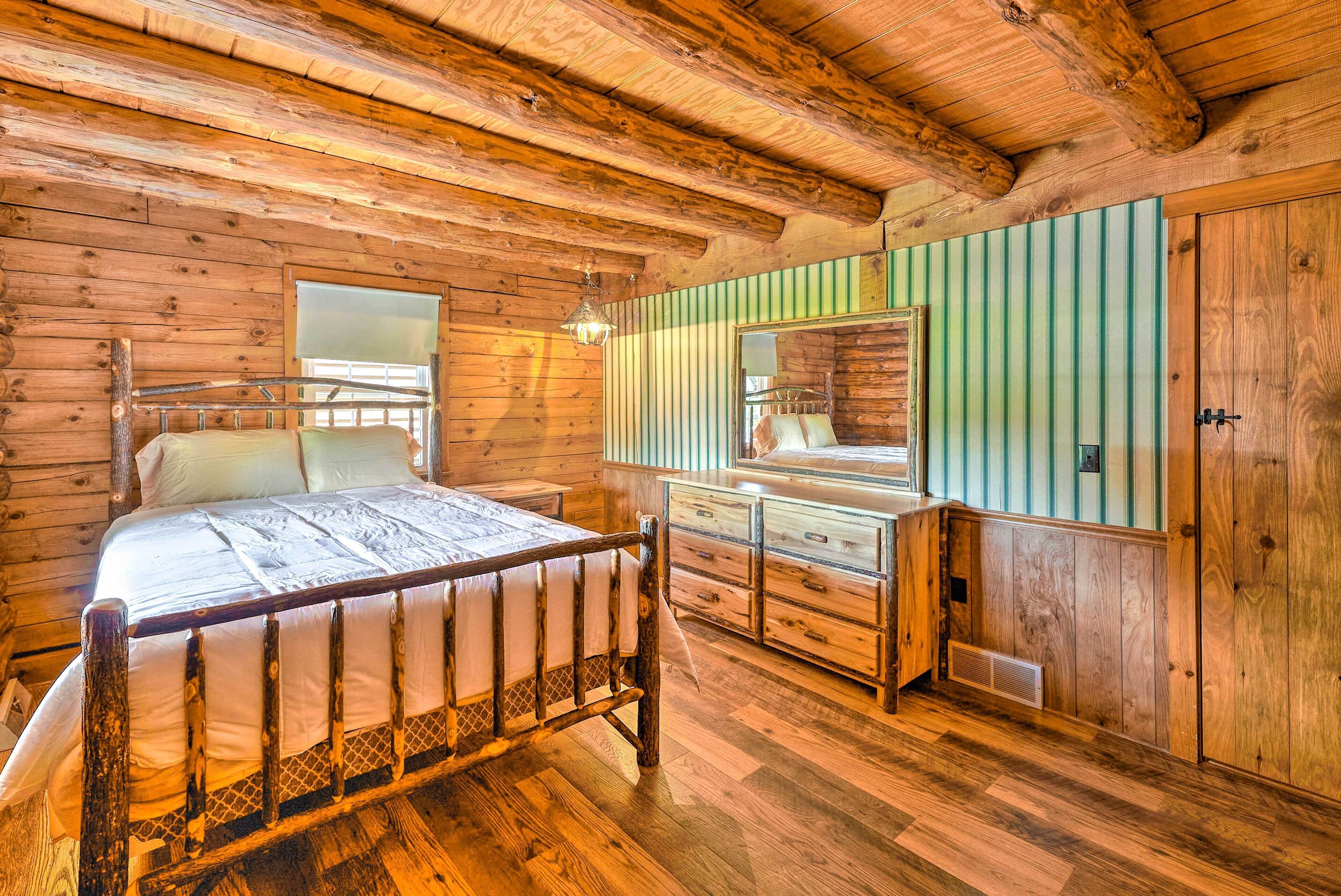 Une chambre à coucher dans une cabane en bois, avec un lit, une commode et une armoire.