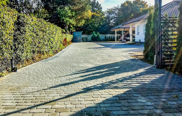 Ein gepflasterter Weg führt zu einem Gebäude mit einer Veranda.