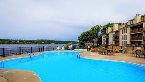 Una piscina con vistas a un lago y un edificio con balcones.