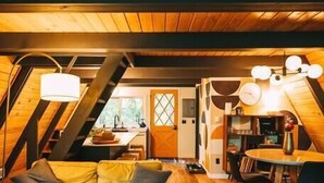 Ein gemütlicher Loft-Wohnbereich mit Sofa, Couchtisch und Esstisch. Eine Treppe führt zu einer erhöhten Ebene.