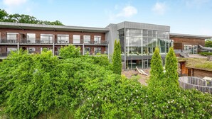 Een modern gebouw met een glazen gevel en een bakstenen buitenkant.