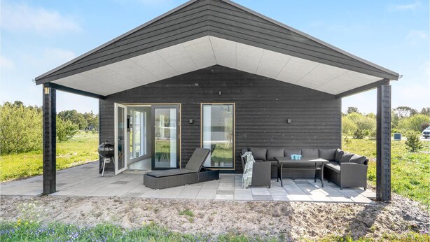A modern outdoor patio with a covered seating area, a barbecue grill, and a glass door entrance. - 3 bedroom beautiful home in Jerup (Jerup)