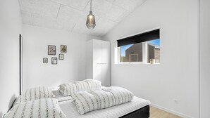 A bedroom with a bed, a hanging light fixture, a window, and artwork on the wall. - 3 bedroom beautiful home in Jerup (Jerup)