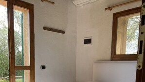A room with a bed, a window, and an air conditioning unit.