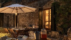A rustic stone building with a dining area set up outside.