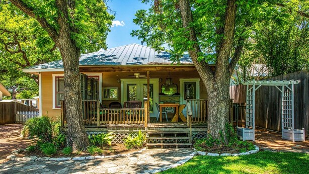 Una casa con porche, comedor y espacio exterior cubierto.