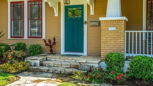 Una casa con un porche de piedra, una puerta verde y un buzón con el número 403.