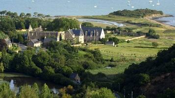 A coastal estate with a large manor house, a church, and a river.