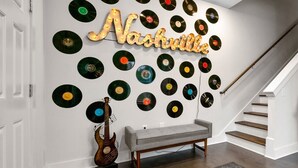 Un mur décoré d’une fresque représentant des disques vinyles et un banc.
