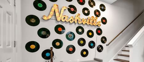 Una pared con un mural de un disco de vinilo y un banco.