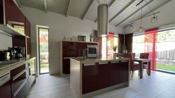 Een moderne keuken met een centraal eiland, inbouwapparatuur en een eetgedeelte met uitzicht.