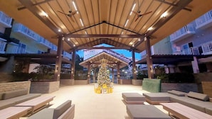 A covered outdoor seating area with benches and a Christmas tree. - Condo Stay Very Near Mactan Airport (Lapu-Lapu)