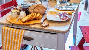 Une table de petit-déjeuner avec divers aliments et une cafetière.
