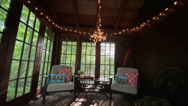 A cozy room with large windows, a wooden ceiling, and string lights. - Quiet cottage nestled in the woods (Mount Gilead)