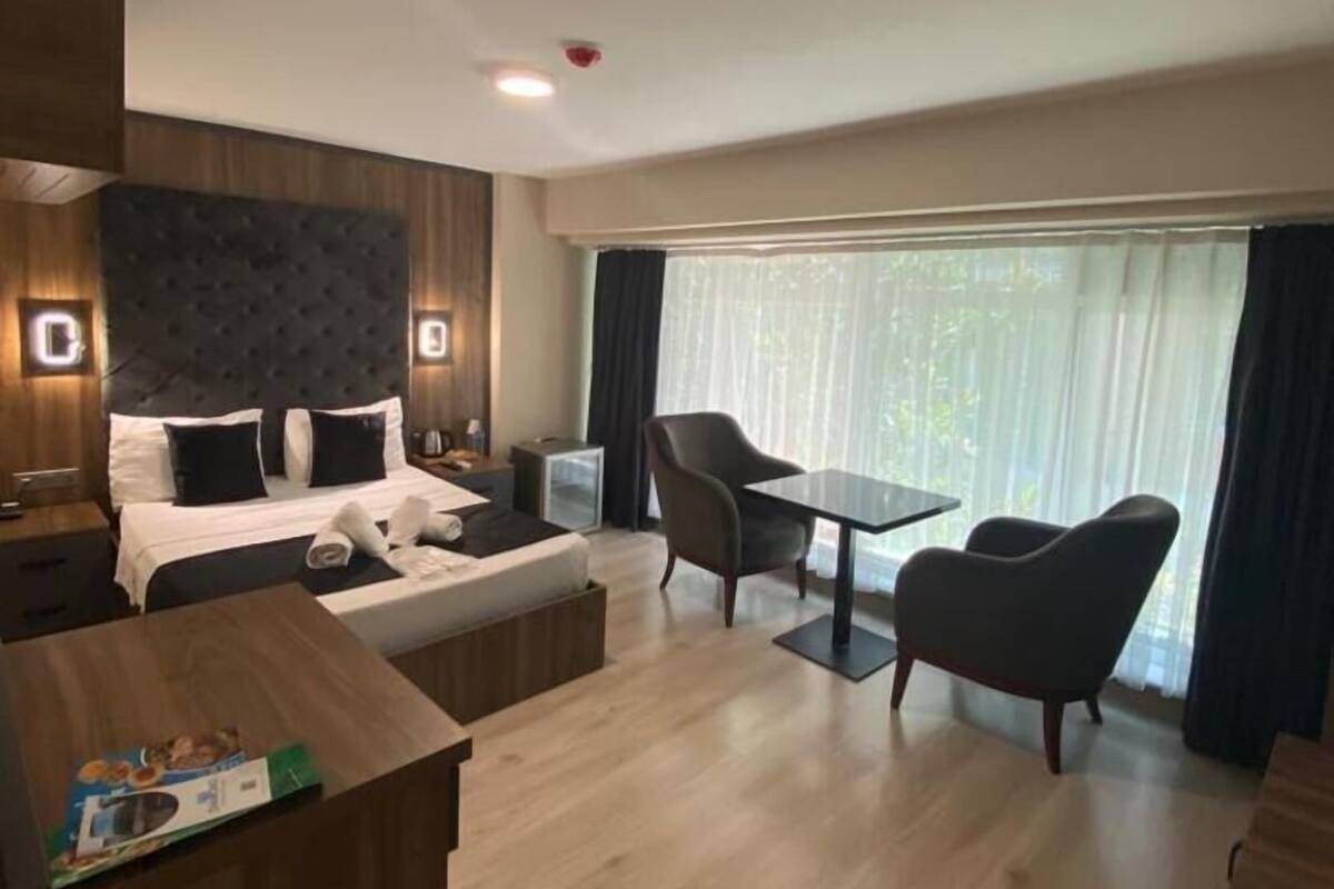 Una habitación de hotel moderna con cama, escritorio y zona de comedor.