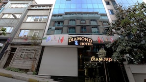 Ett hotell med en modern fasad av glas och en skylt med texten ”DIAMOND HOTEL”.