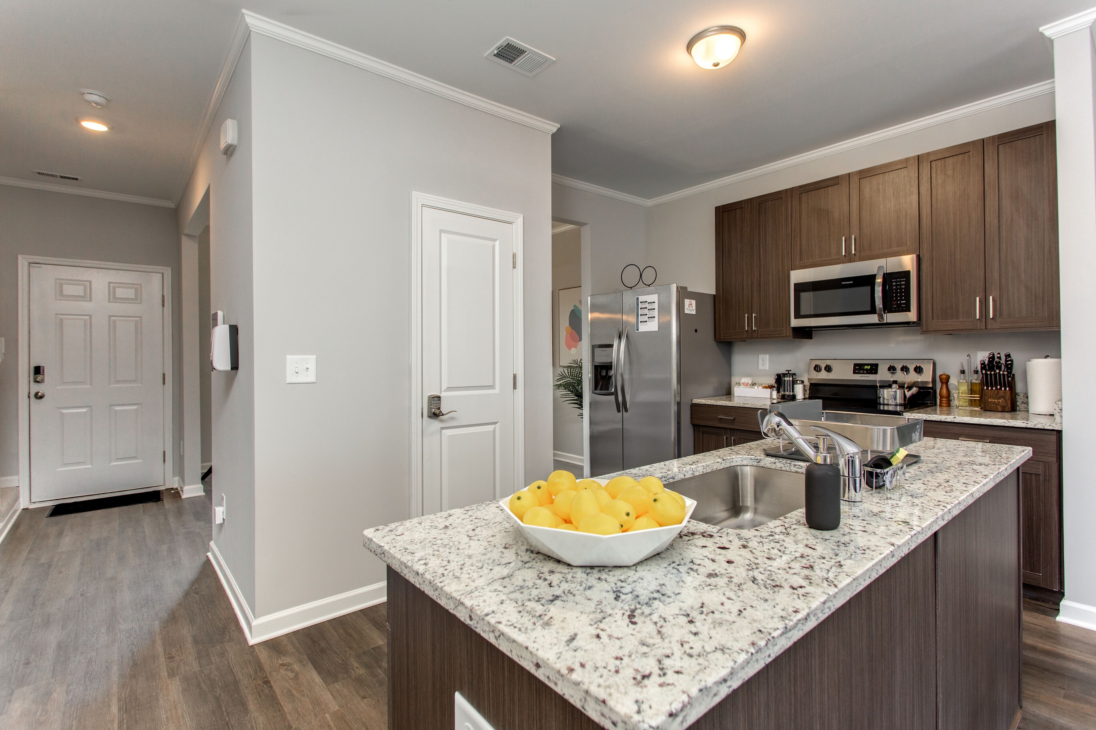 A modern kitchen with granite countertops, stainless steel appliances, and wooden cabinets.