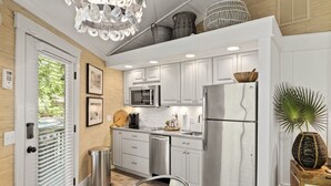 A modern kitchen with white cabinets, stainless steel appliances, and a dining area with a glass table and chairs.