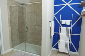 Een bad/douchecombinatie, handdoeken, zeep, shampoo