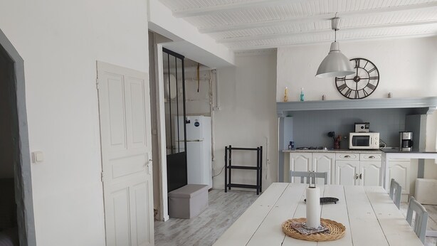 A modern kitchen with white cabinets, a microwave, and a gas stove. - 3 bedroom house (Siaugues-Sainte-Marie)