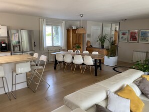 Relax in this stylish living space with a dining area, sofa, and kitchen.