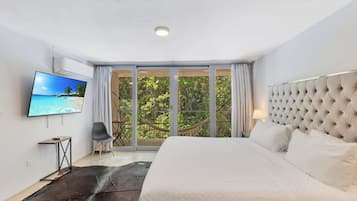 Habitación de hotel moderna con una cama grande, un televisor, una mesita y vistas al exterior a través de un ventanal.