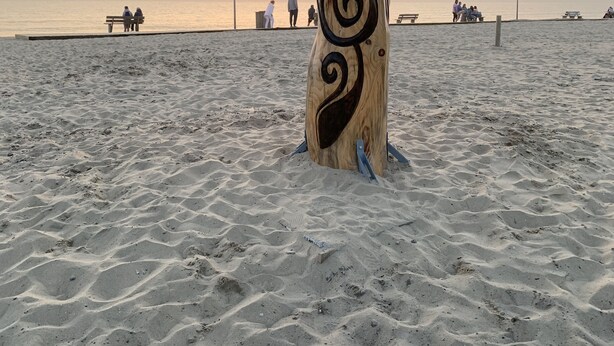 A wooden sculpture with intricate carvings on a sandy beach at sunset. - Seaside villa with large pool and terrace (Vendays-Montalivet)