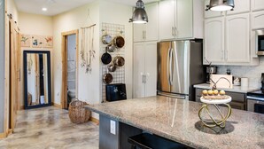 A kitchen with granite countertops, stainless steel appliances, hanging pots, and pendant lighting. - Artisan Boho, Equine Too, Farm Fresh Eggs, Spa, Vino & Views! (Sebastopol)